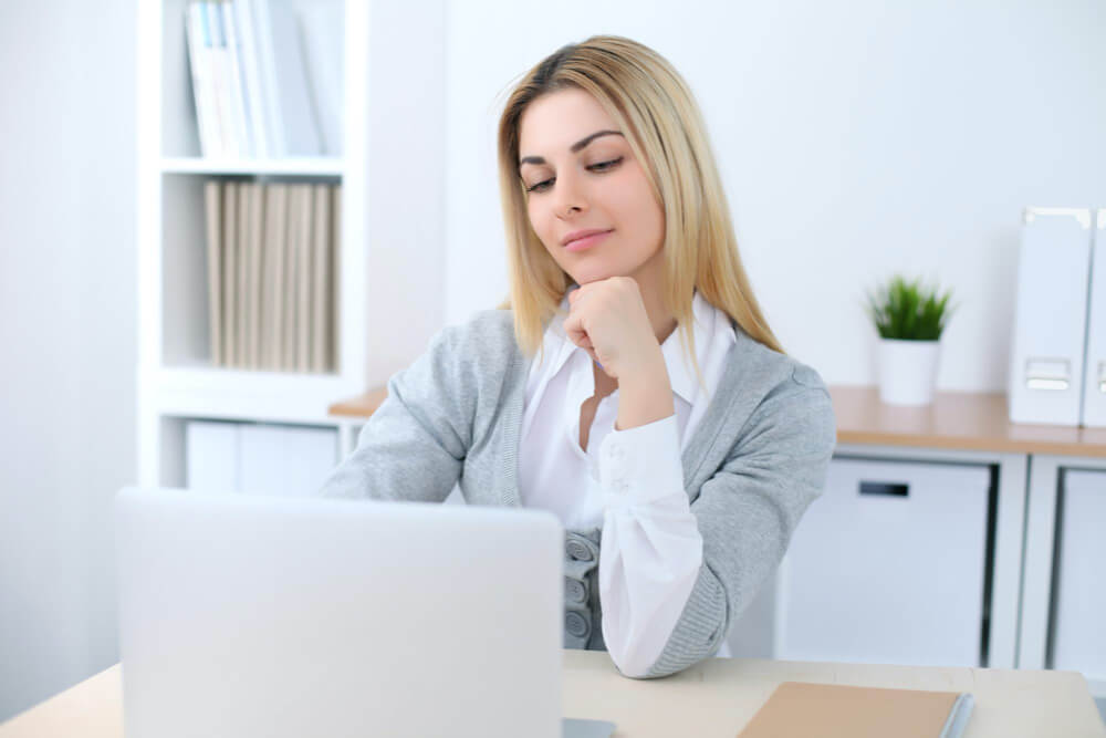 Junge Frau im Büro bei der Arbeit mit einer Business-Software.